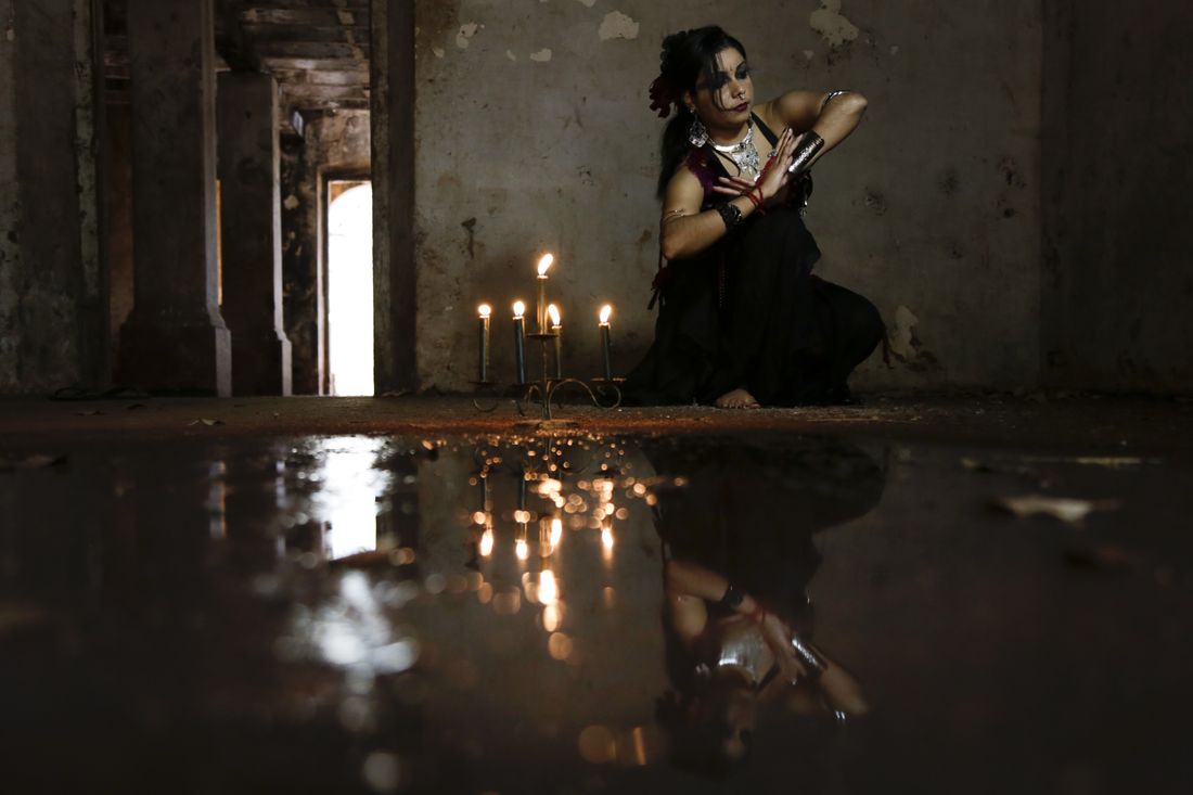 Gilmara ajoelhada, refletida no chão alagado