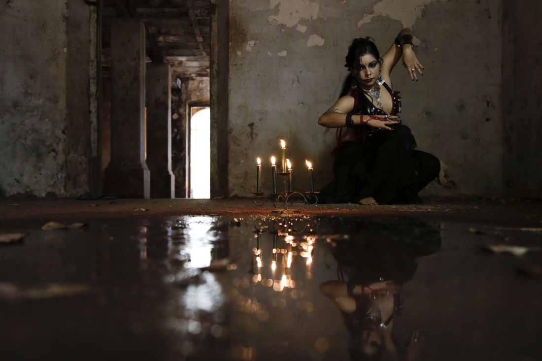 Gilmara entre velas, refletida na água