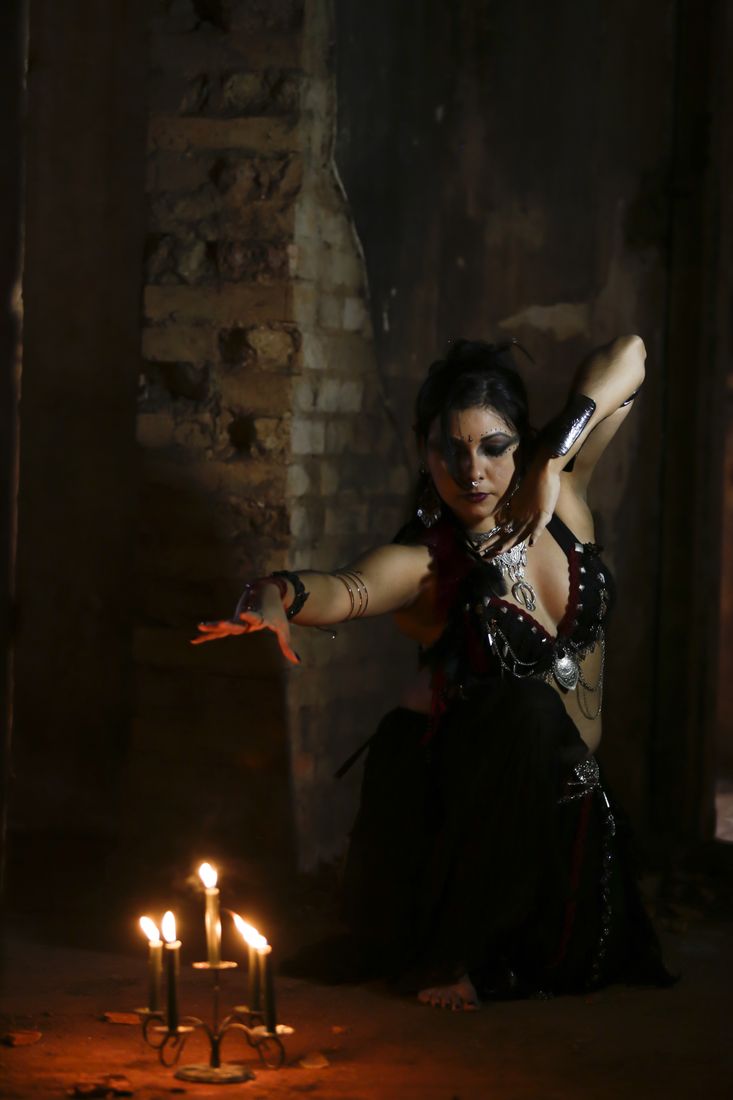 Gilmara dançando ajoelhada entre velas